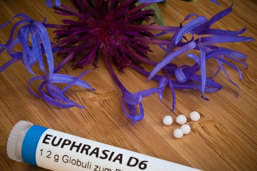 होम्योपैथिक दवा की गोलियाँ और पुष्प